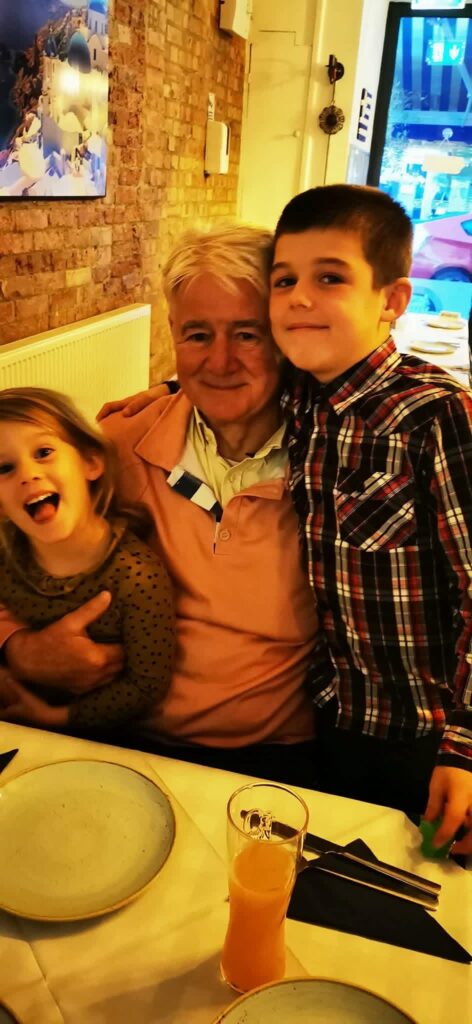 Len with grandchildren at a restaurant