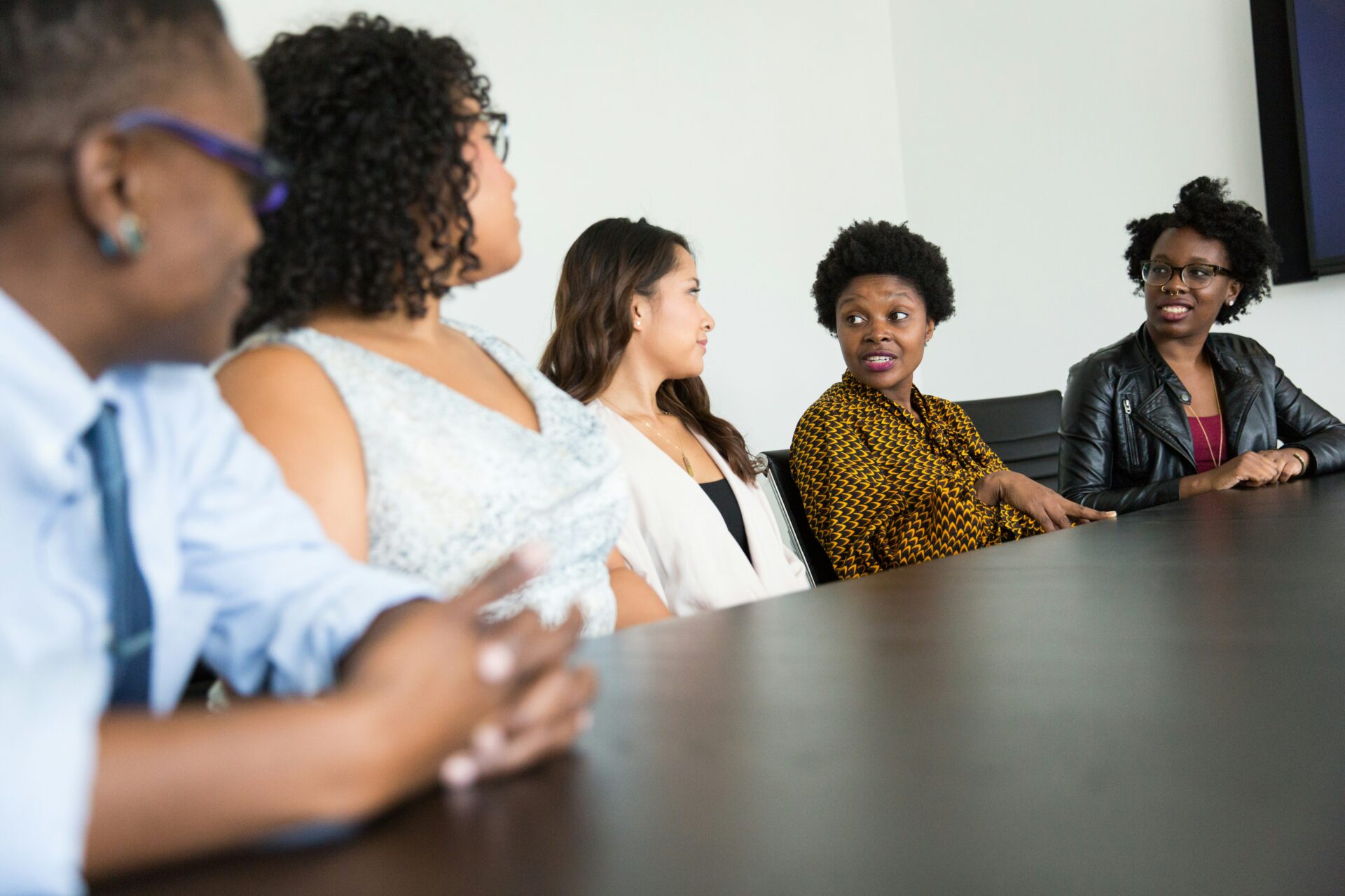 Group seated around a conference table in a modern office, engaged in a team discussion 