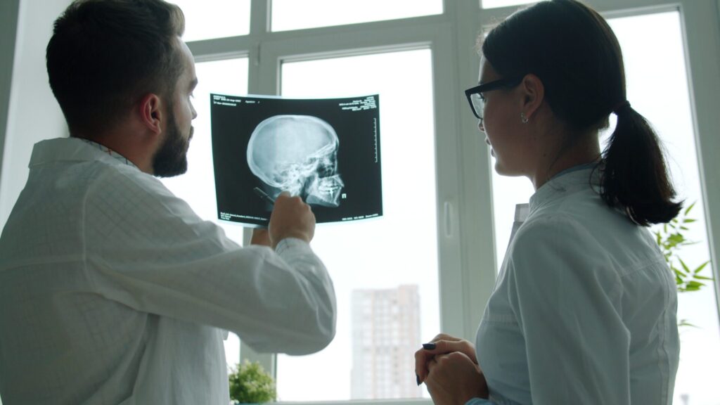 professionals reviewing a skull X-ray in a medical office