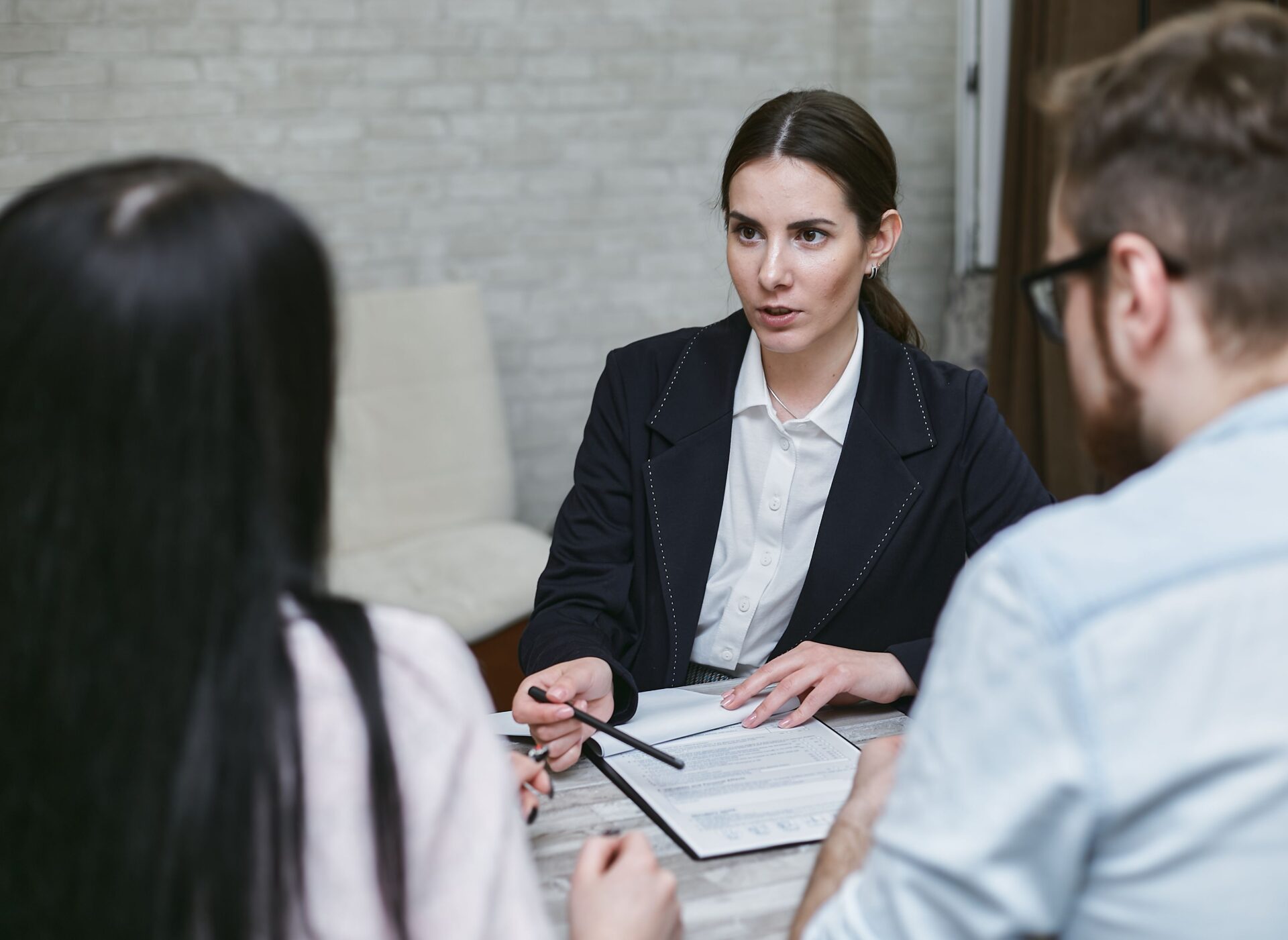 Professional consultation meeting with a client reviewing documents across a desk